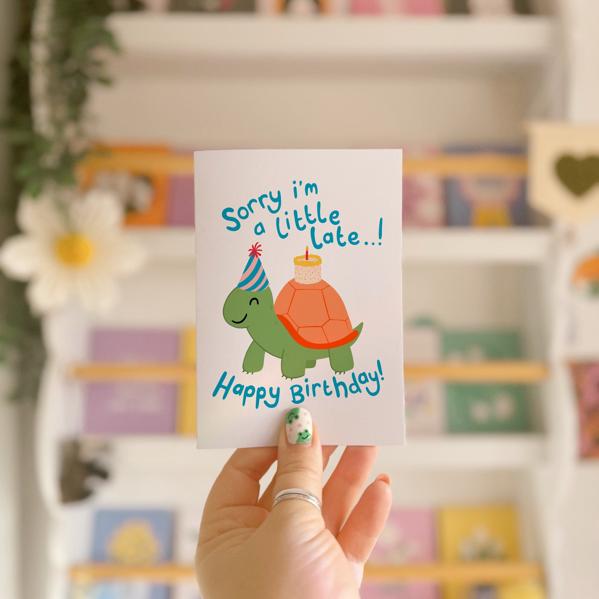 Birthday card with a tortoise wearing a party hat and text on a blue background