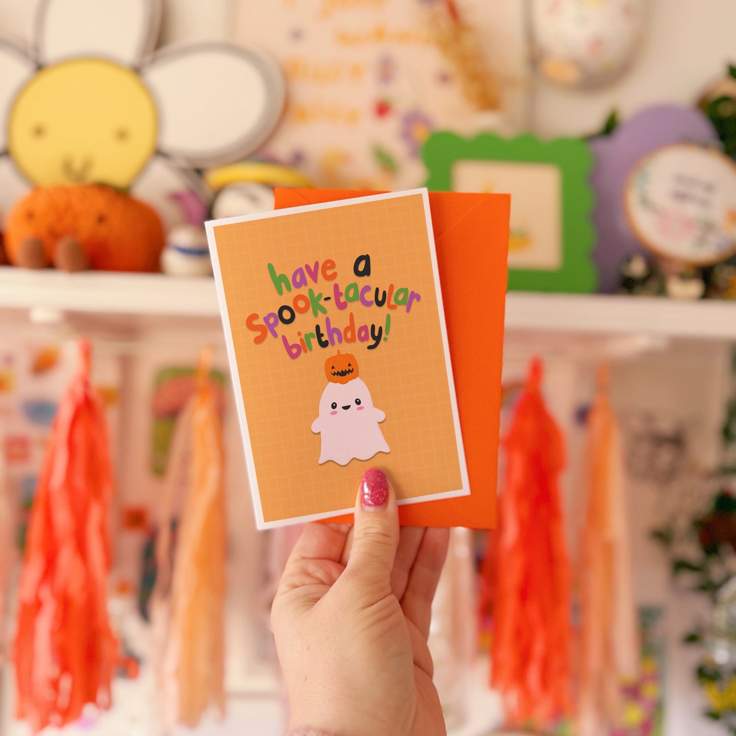 A halloween themed birthday card, with a cute ghost illustration and writing that says 'have a spook-macular birthday!'.