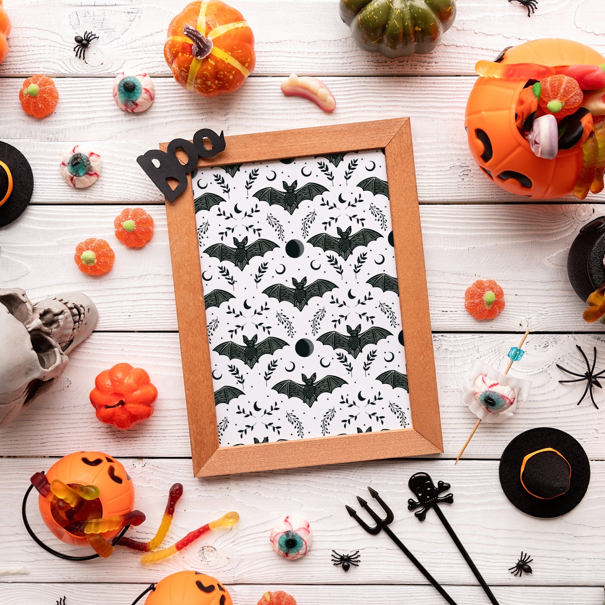 A print with a repeating pattern of black bats with moon and floral elements.