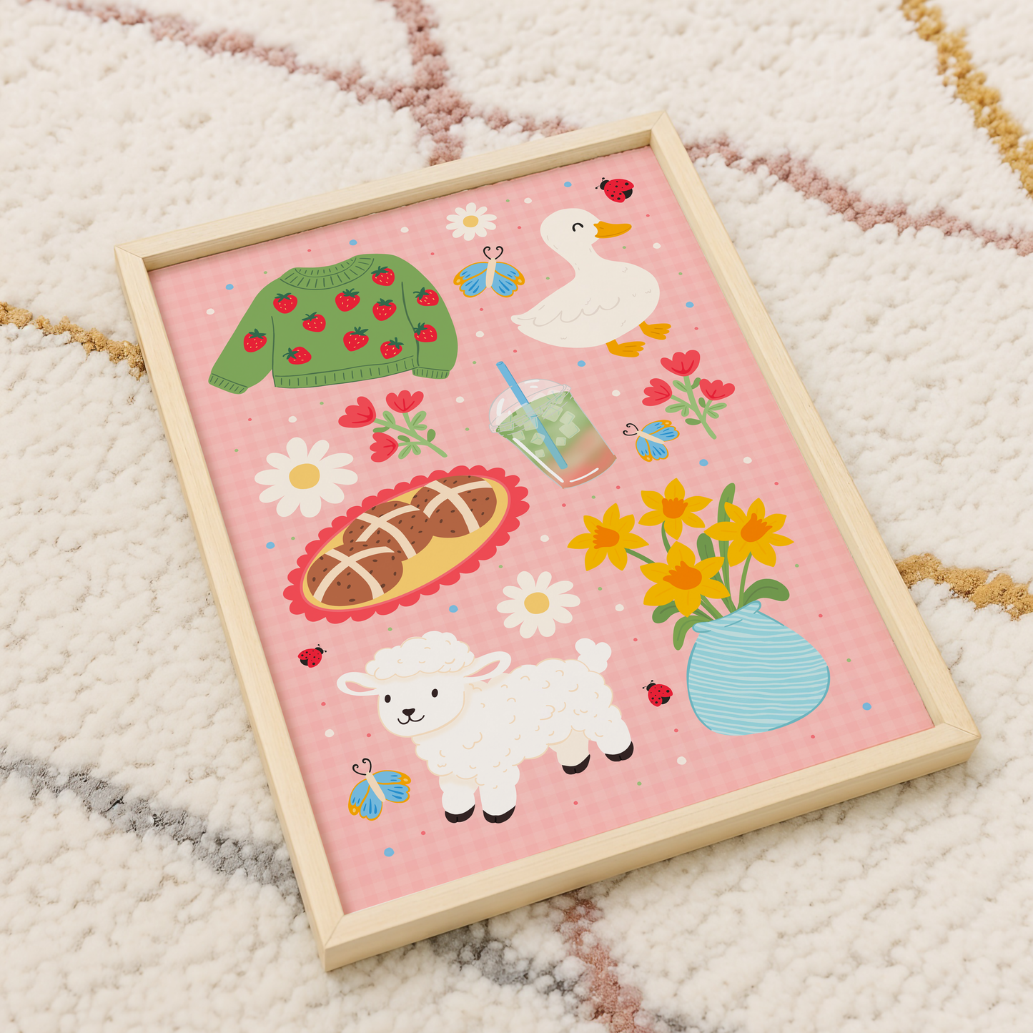 A pink gingham print, with spring themed illustrations - hot cross bunds, iced matcha latte, a duck, a lamb, daffodils and a strawberry print jumper.