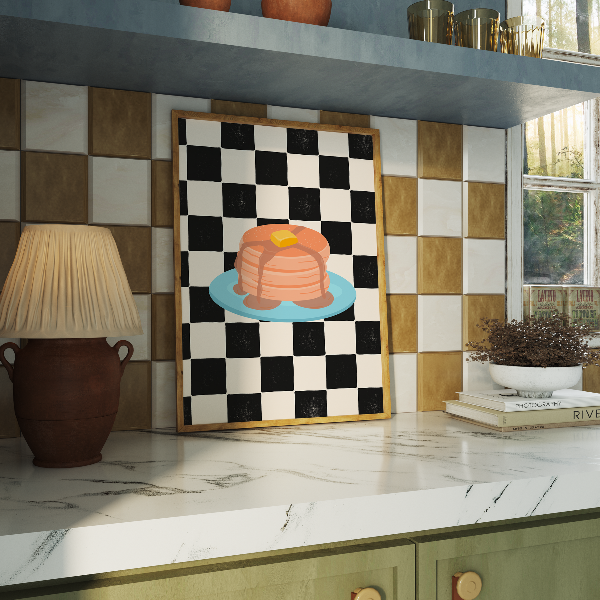 A framed art print featuring a black and white checkered pattern with a colourful illustration of pancakes on a blue plate.