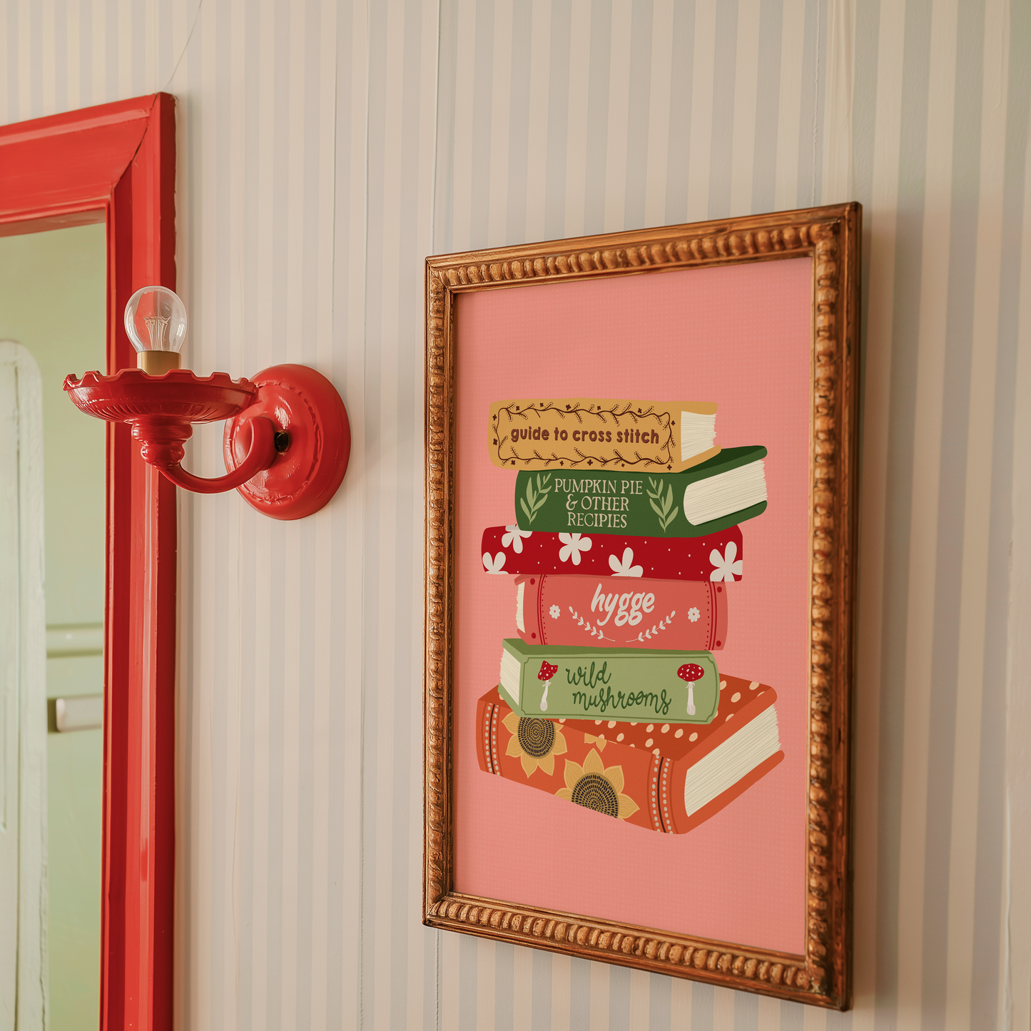 A print featuring six books stacked on top of each other, in autumnal shades and themes on a peachy pink background.