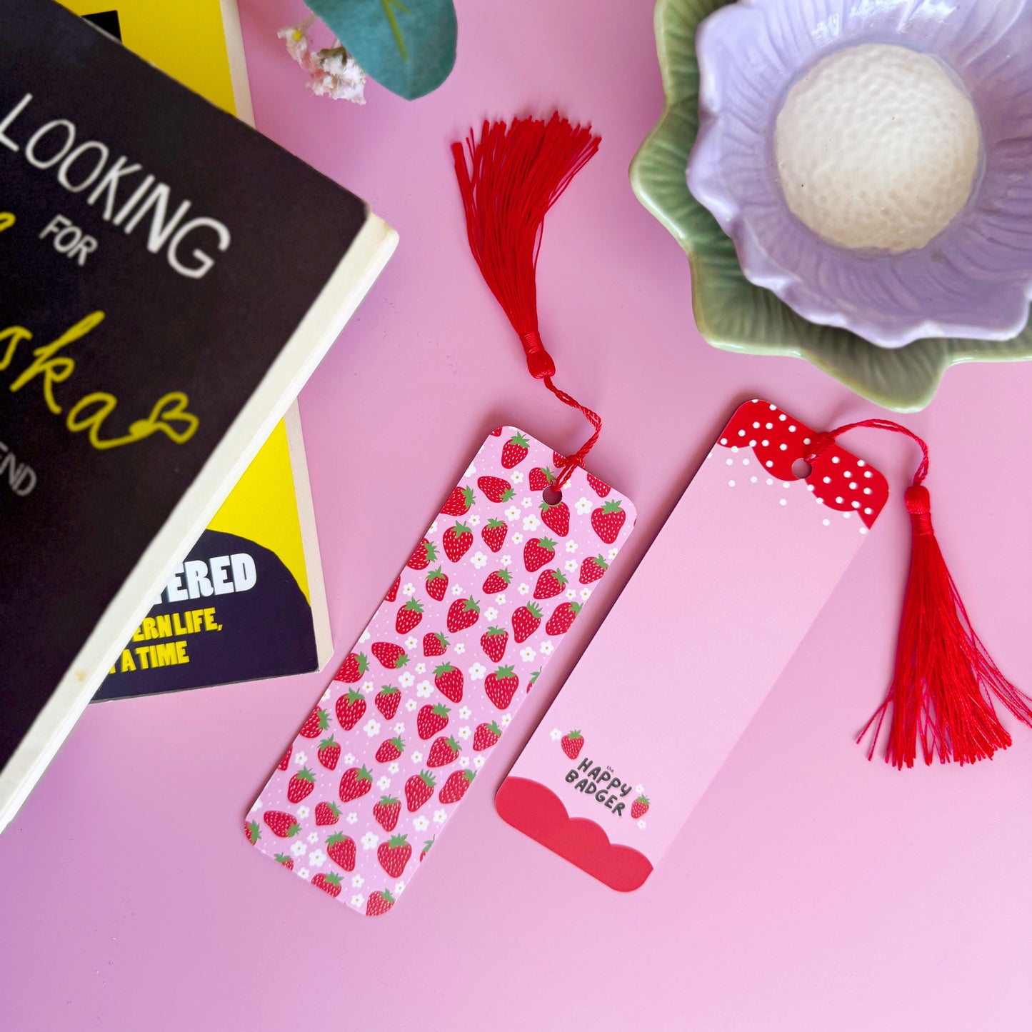 A pink and red strawberry patterned bookmark with a coordinating red tassel.