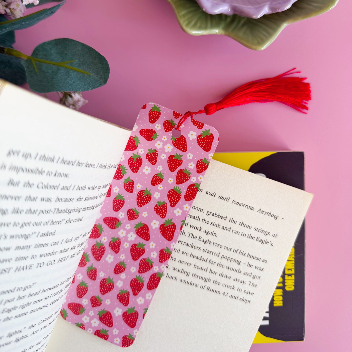 A pink and red strawberry patterned bookmark with a coordinating red tassel.