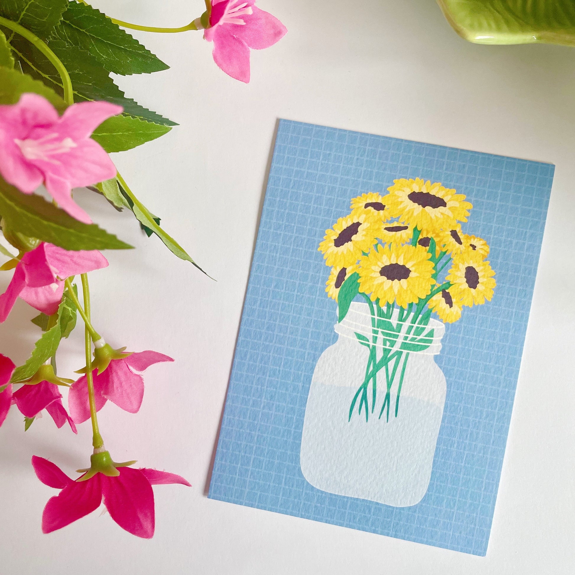 A textured postcard, with an illustration of a vase of sunflowers on the front.