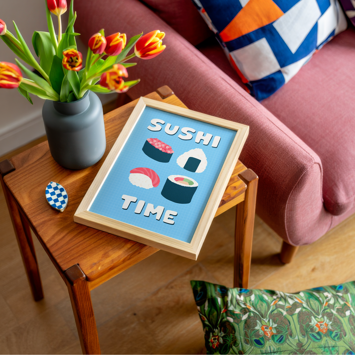 A blue wall art print, with illustrations of sushi in the centre. Around the sushi illustration, are the words 'Sushi Time' in a fun bold white font.
