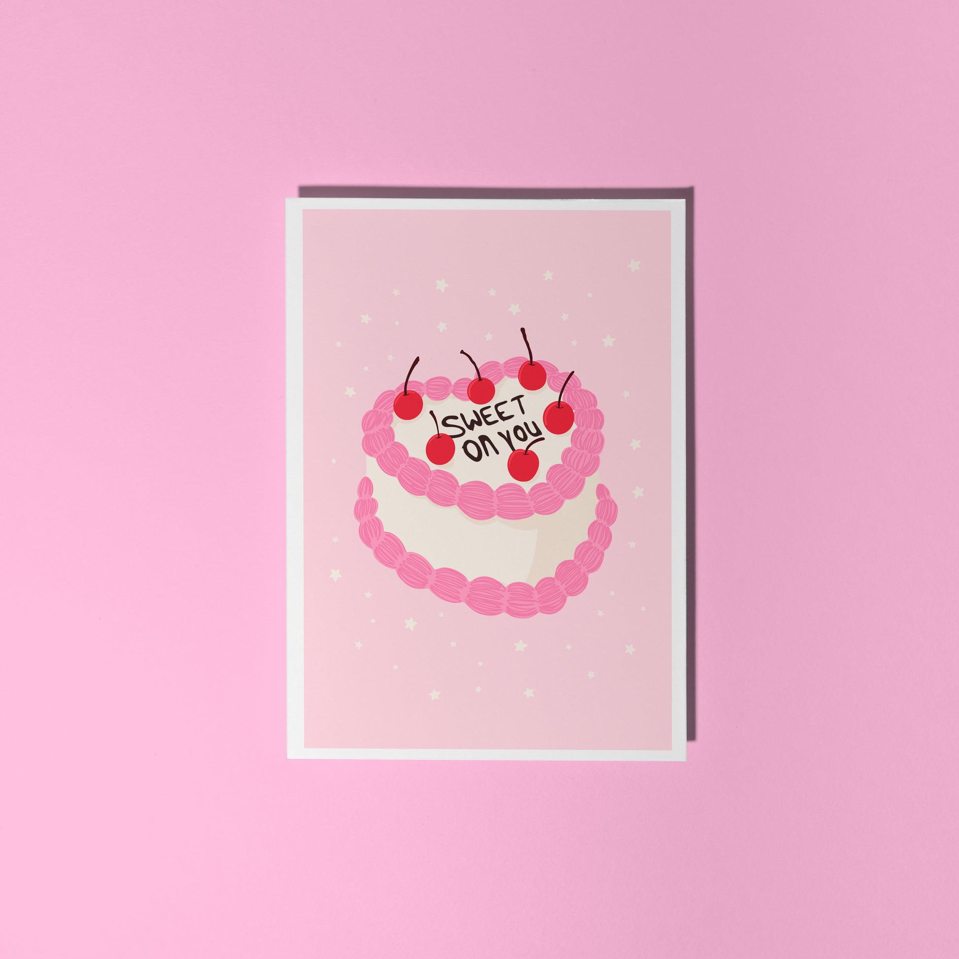 A pink love themed card, with a cake illustration. There is black icing on the cake says 'sweet on you' and the rest of the cake has cherries and pink and white icing.
