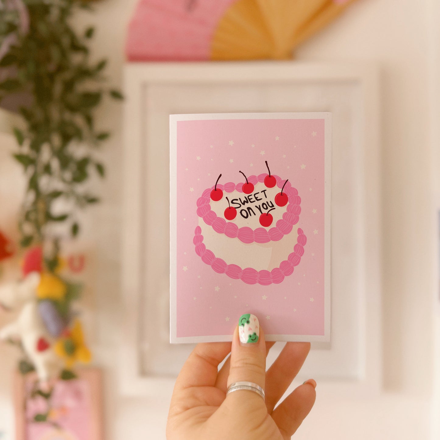 A pink love themed card, with a cake illustration. There is black icing on the cake says 'sweet on you' and the rest of the cake has cherries and pink and white icing.