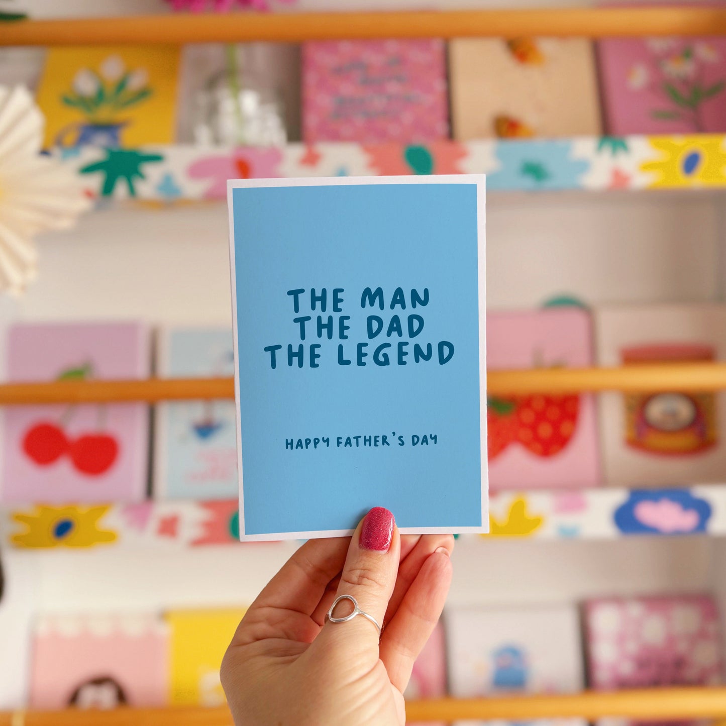 A blue card with text that reads 'the man the dad the legend, happy fathers day'.