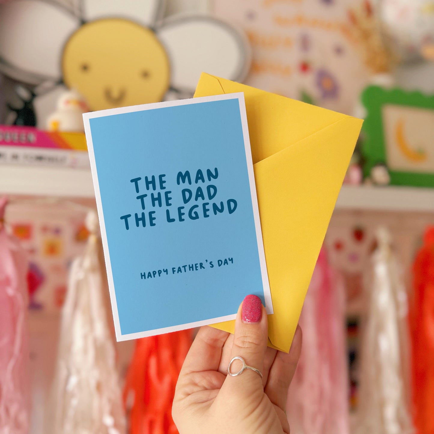 A blue card with text that reads 'the man the dad the legend, happy fathers day'.