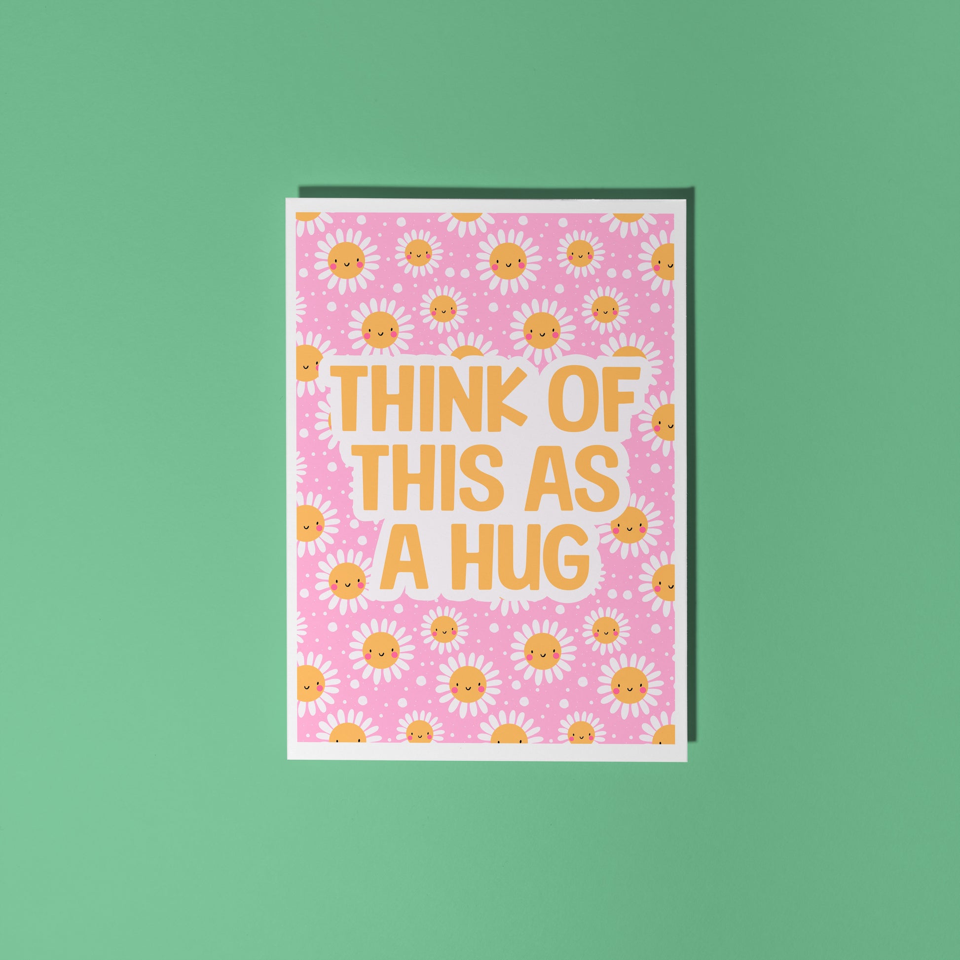Hand holding a pink card with yellow smiling flowers and text that says 'Think of this as a hug'.