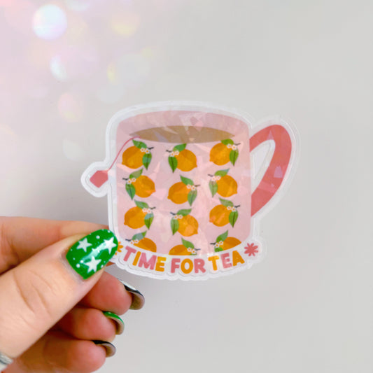 A holographic sticker, with a mug with lemons on it, and text underneath saying 'time for tea'. The sticker has an easy peel lip.