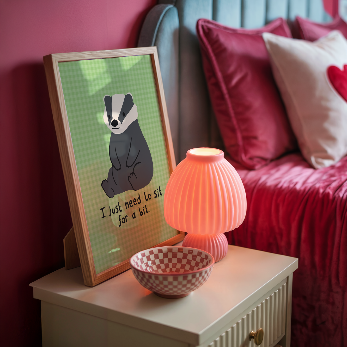 A green gingham print, with an illustration of a badger sat down, and a quote that reads 'I just need to sit for a bit'.