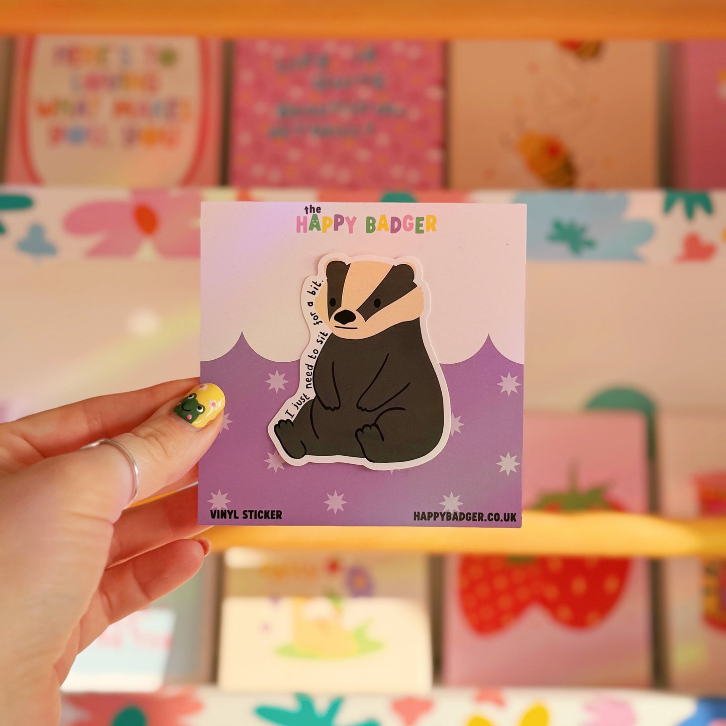 A waterproof vinyl sticker featuring a badger illustration, and text that reads 'I just need to sit for a bit'.