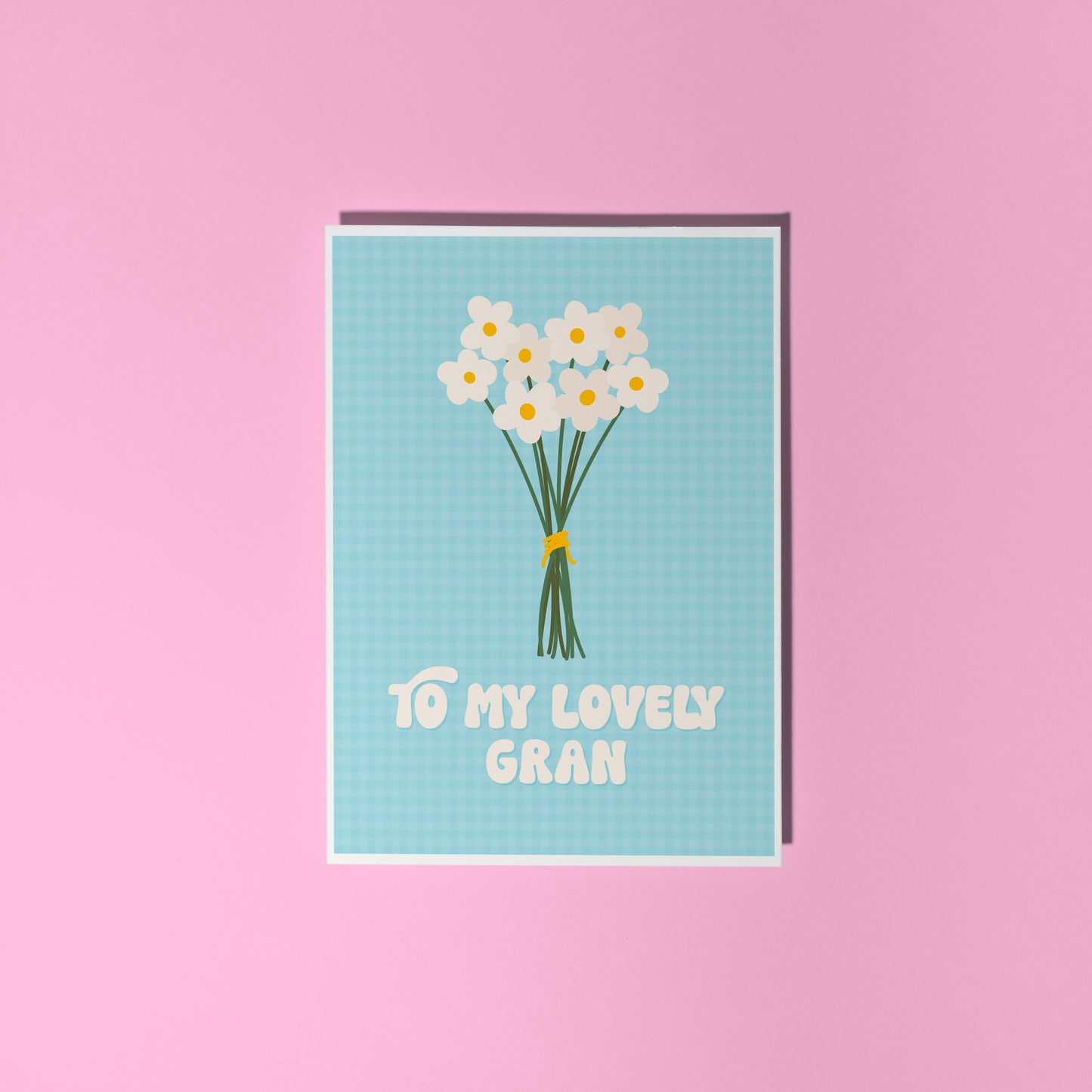 A blue greeting card with the words 'to my lovely Gran' on the front, with a bunch of daisies.
