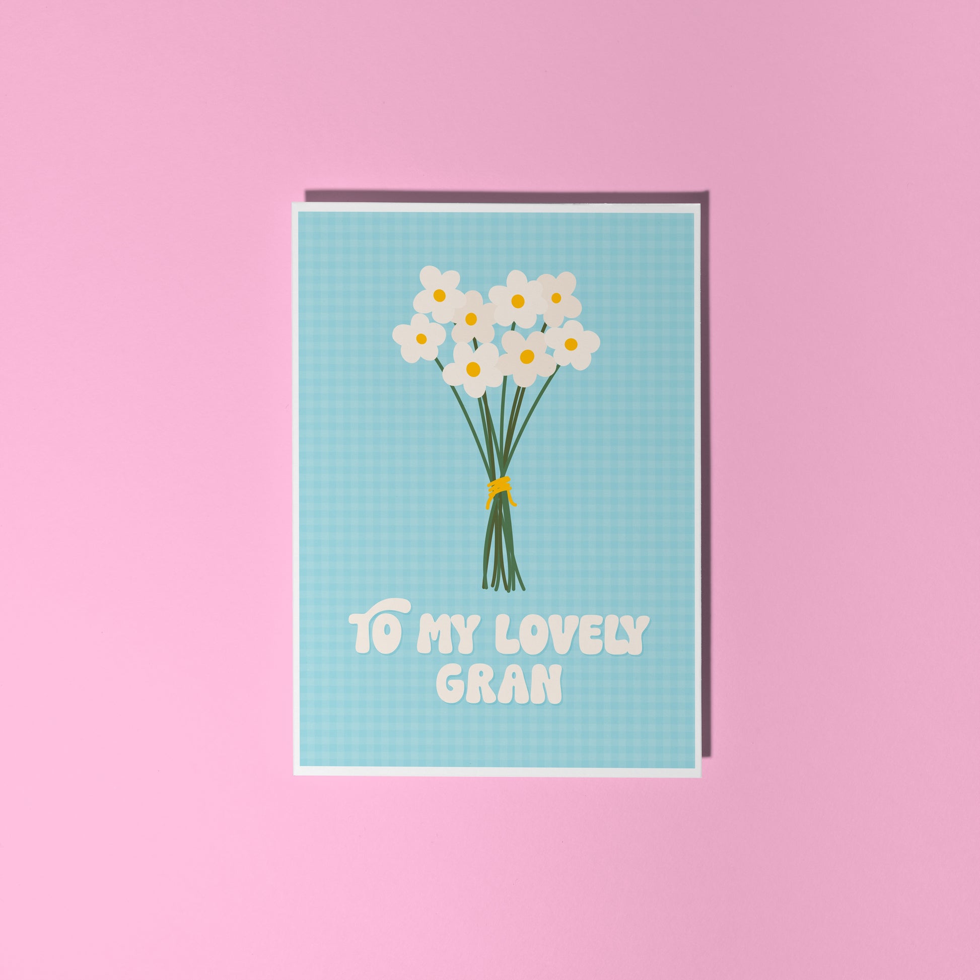 A blue greeting card with the words 'to my lovely Gran' on the front, with a bunch of daisies.