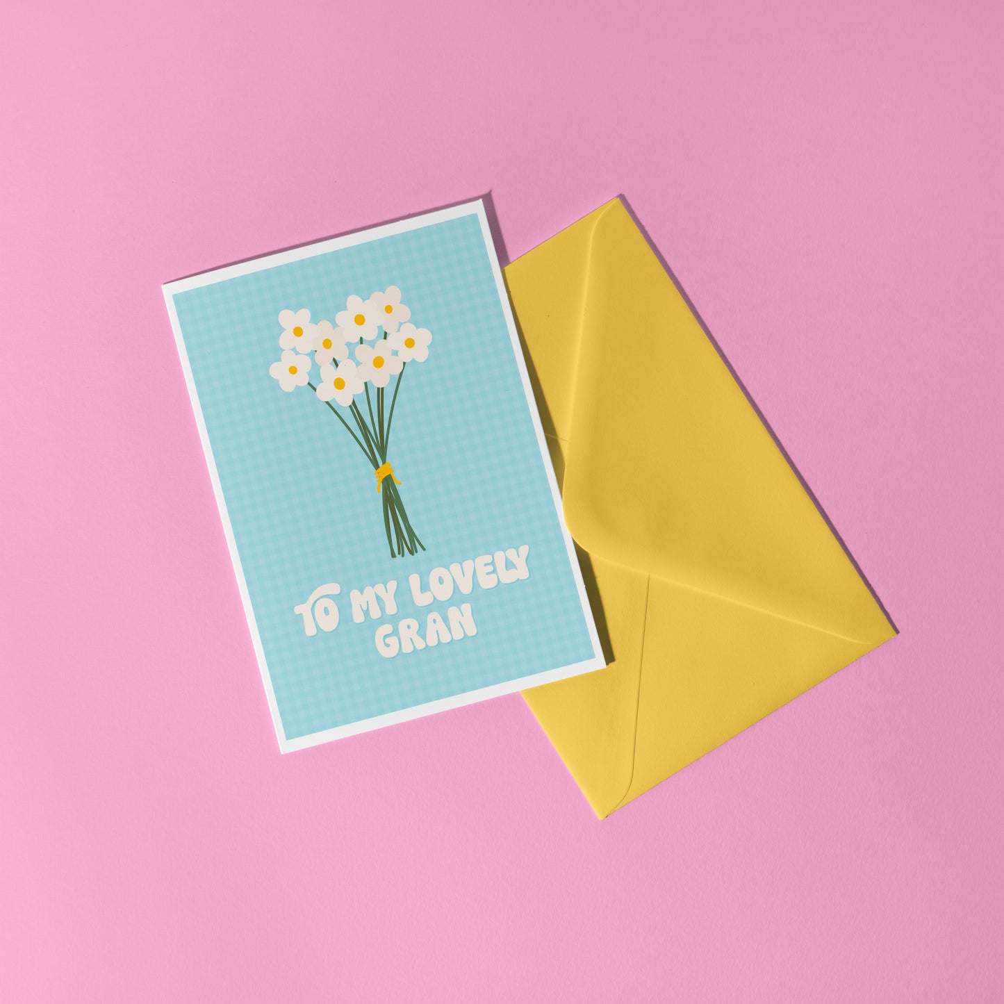 A blue greeting card with the words 'to my lovely Gran' on the front, with a bunch of daisies.