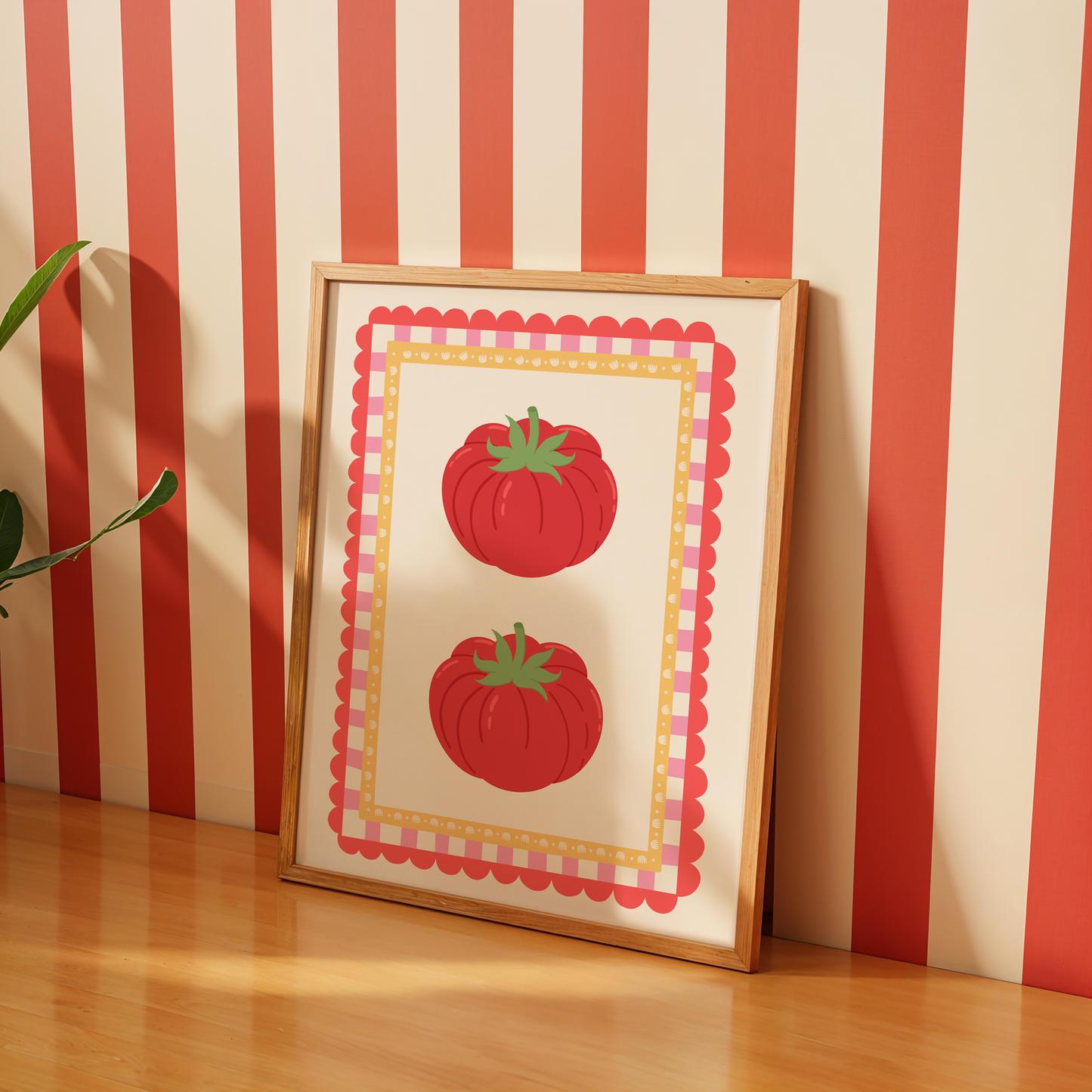 Framed artwork with red tomato design against a striped wall.
