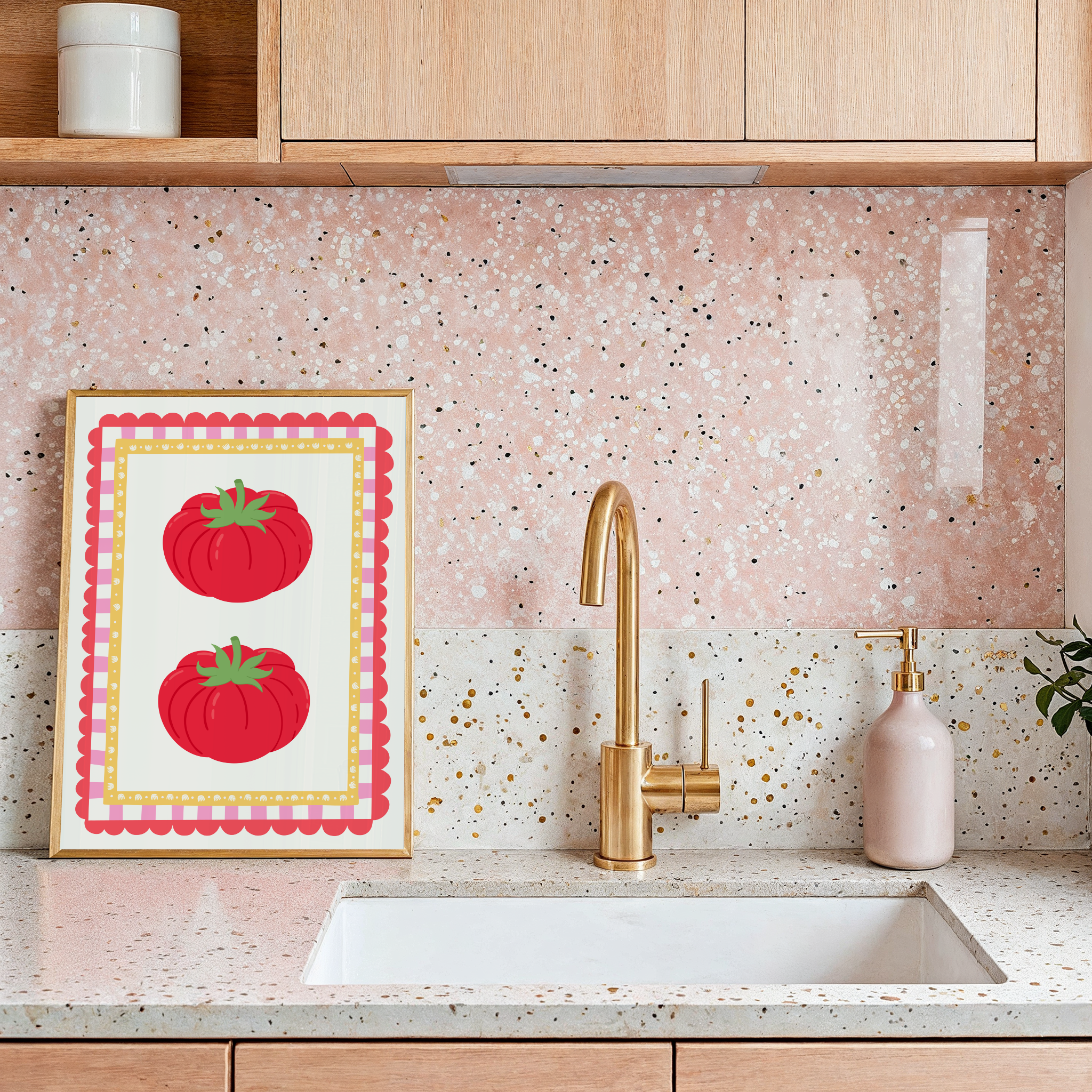 Kitchen with pink speckled backsplash, gold faucet, and framed artwork of red tomatoes.
