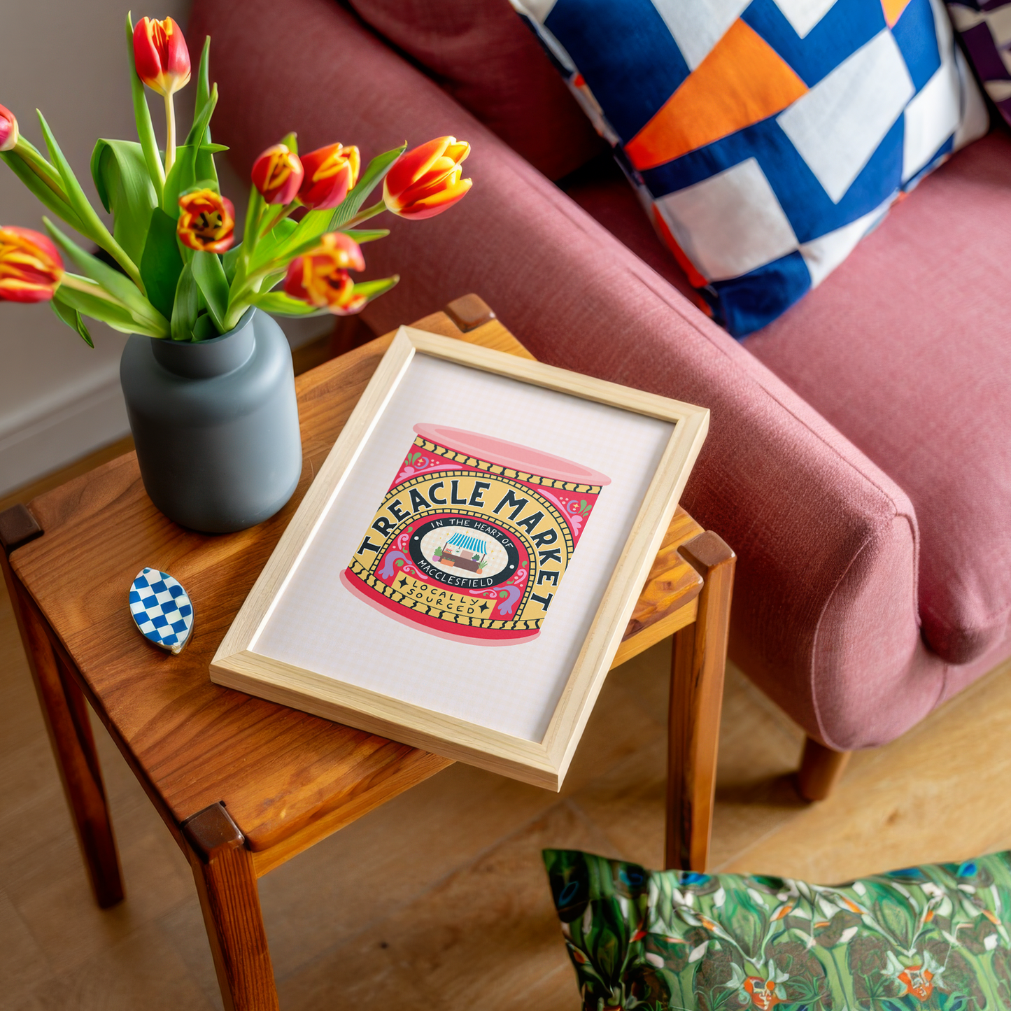 An illustrated art print of a a tin of treacle - but designed in ode to the Treacle Market in Macclesfield. THe print has bold red and yellow hues. 