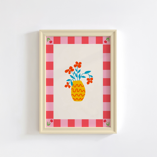 A colourful bright print, with a pink tonal checkerboard border, and an illustration of a simple modern yellow vase in the centre with red flowers.