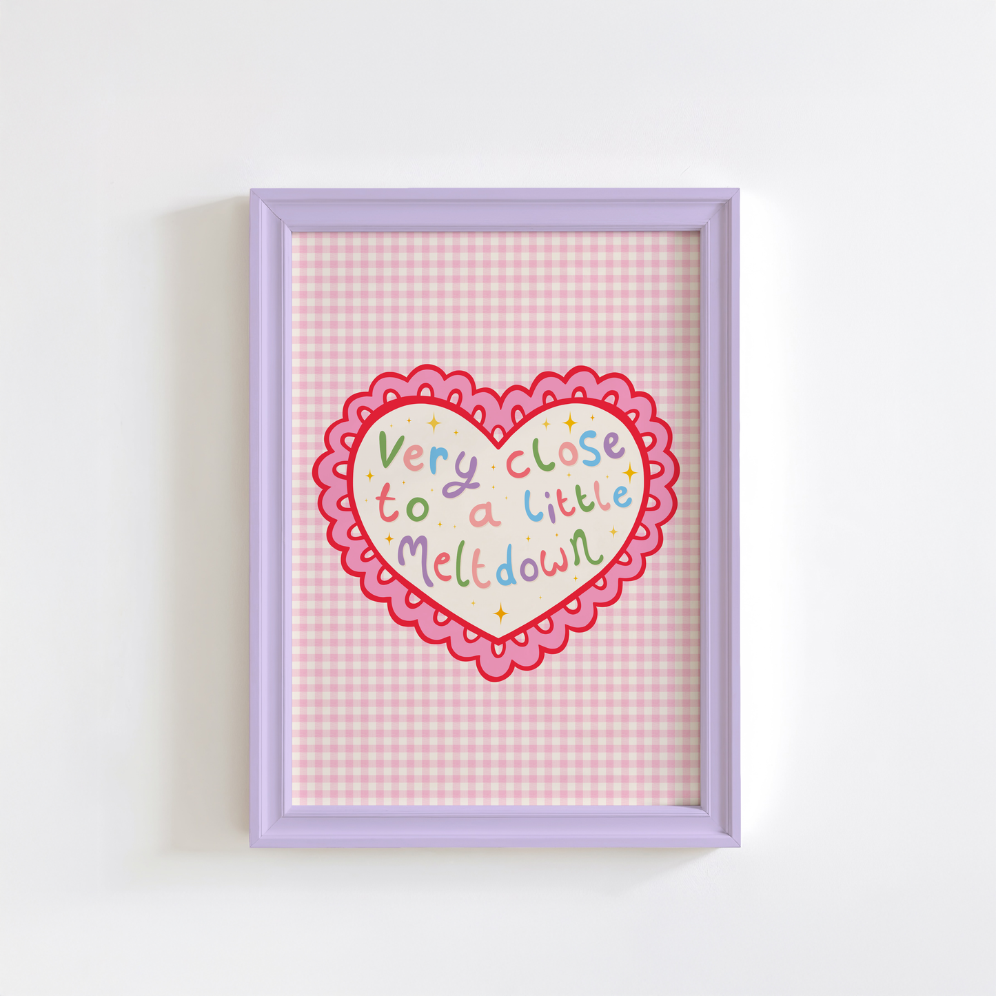 A pink print, shown in a frame, of a heart with a scallop edge. Inside the heart are the words 'very close to a little meltdown'.