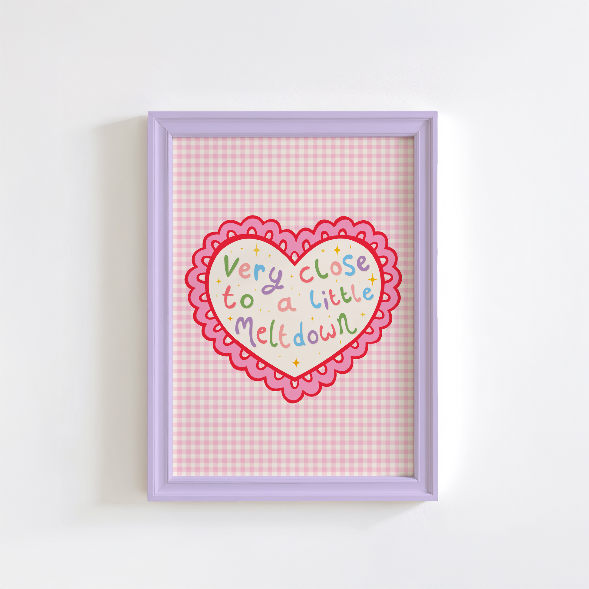 A pink print, shown in a frame, of a heart with a scallop edge. Inside the heart are the words 'very close to a little meltdown'.