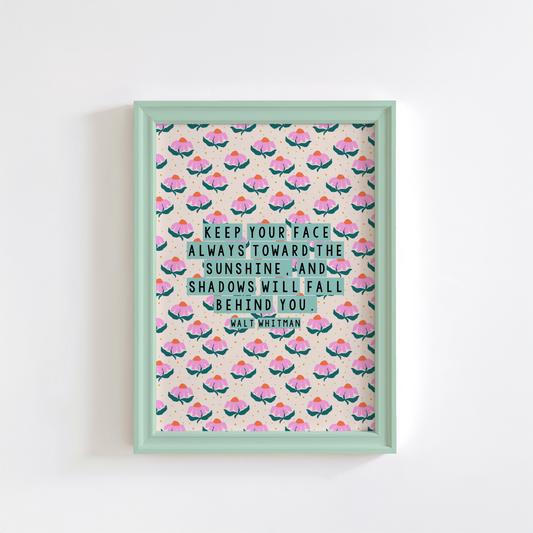 A pink, teal and cream floral patterned print, with a well known quote by Walt Whitman, saying keep our face always toward the sunshine, and the shadows will fall behind you.