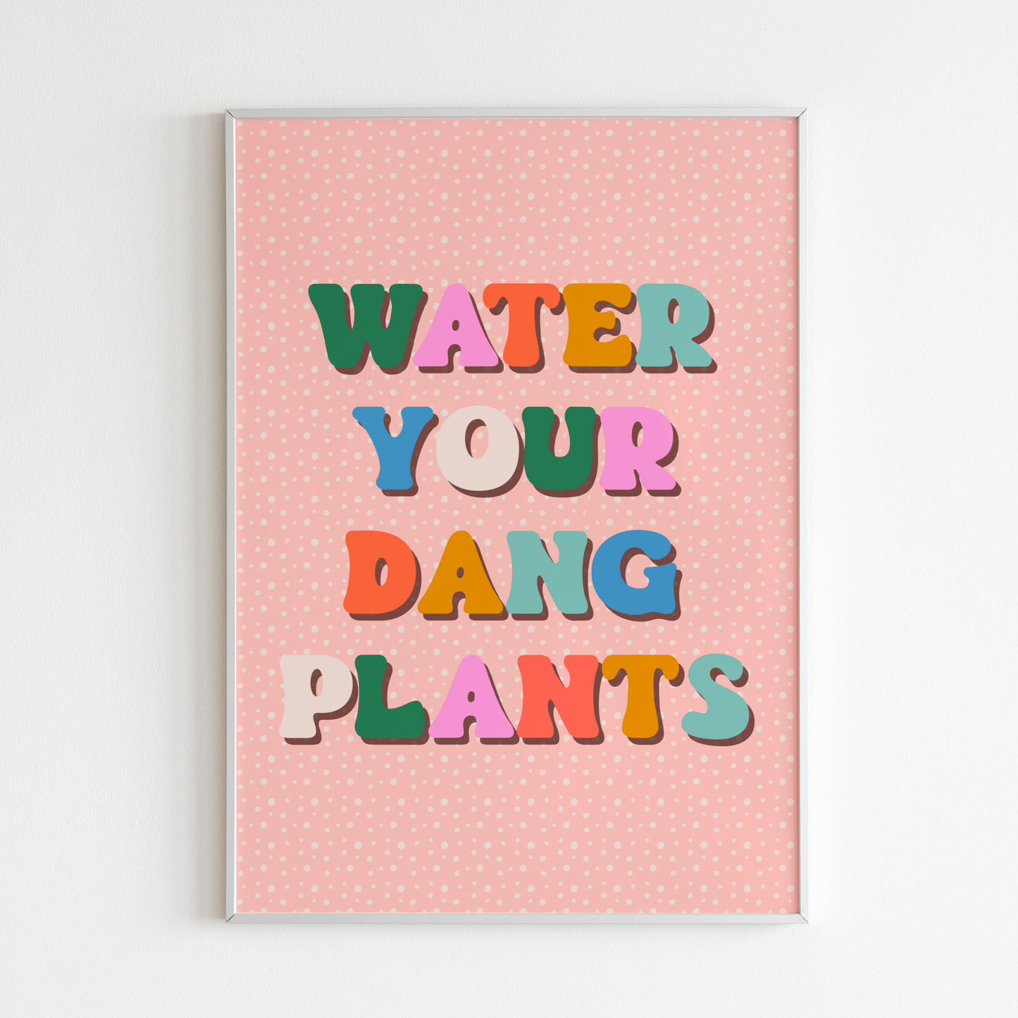 A quote print, saying water your dang plants, in multicoloured text on a peachy pink background.