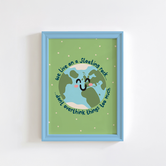 A green print with an illustration of a smiling planet earth. Around the earth is text that reads 'we live on a floating rock... don't overthink things too much.'