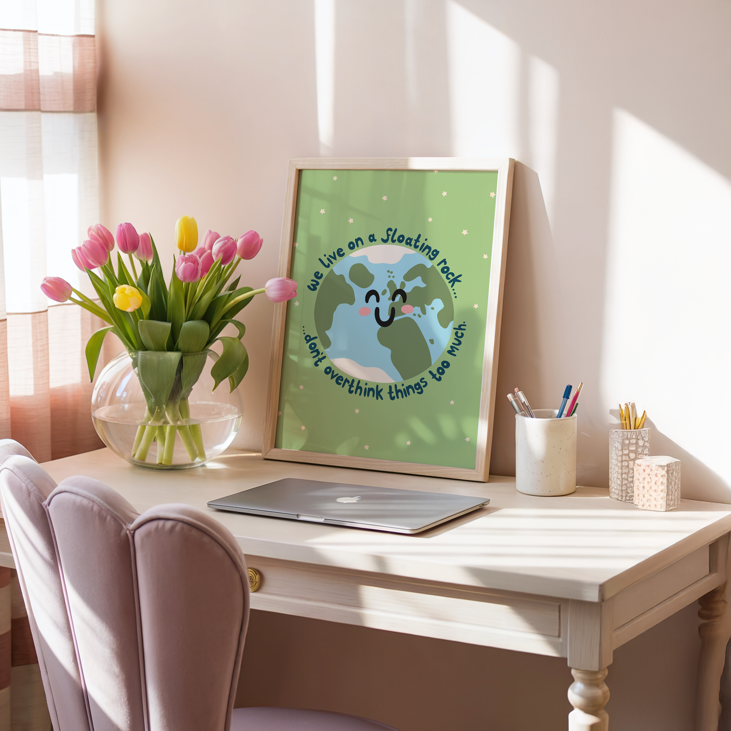 A green print with an illustration of a smiling planet earth. Around the earth is text that reads 'we live on a floating rock... don't overthink things too much.'