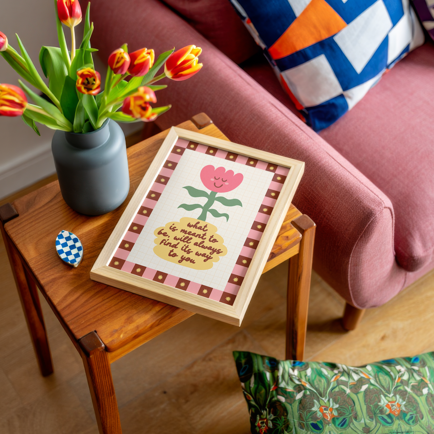 An illustration of a smiling tulip in a yellow vase, which has a positive quote written on it. Around the illustration is a hand drawn pink and brown checkerboard border with yellow stars.