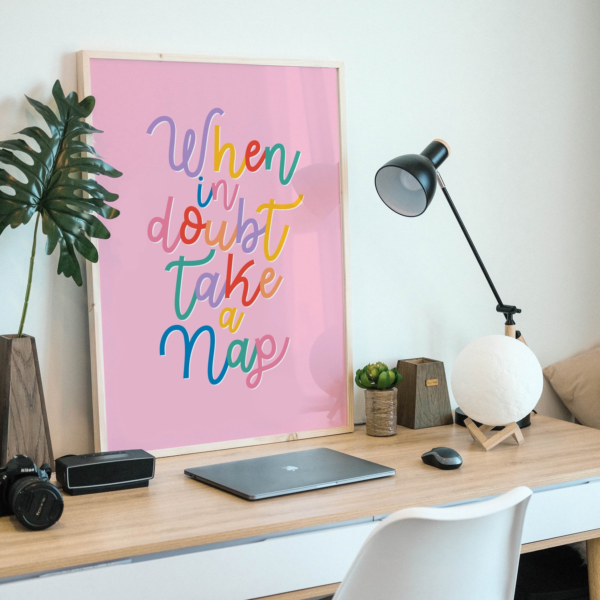A fun quote print with text saying when in doubt take a nap, on a pink background.