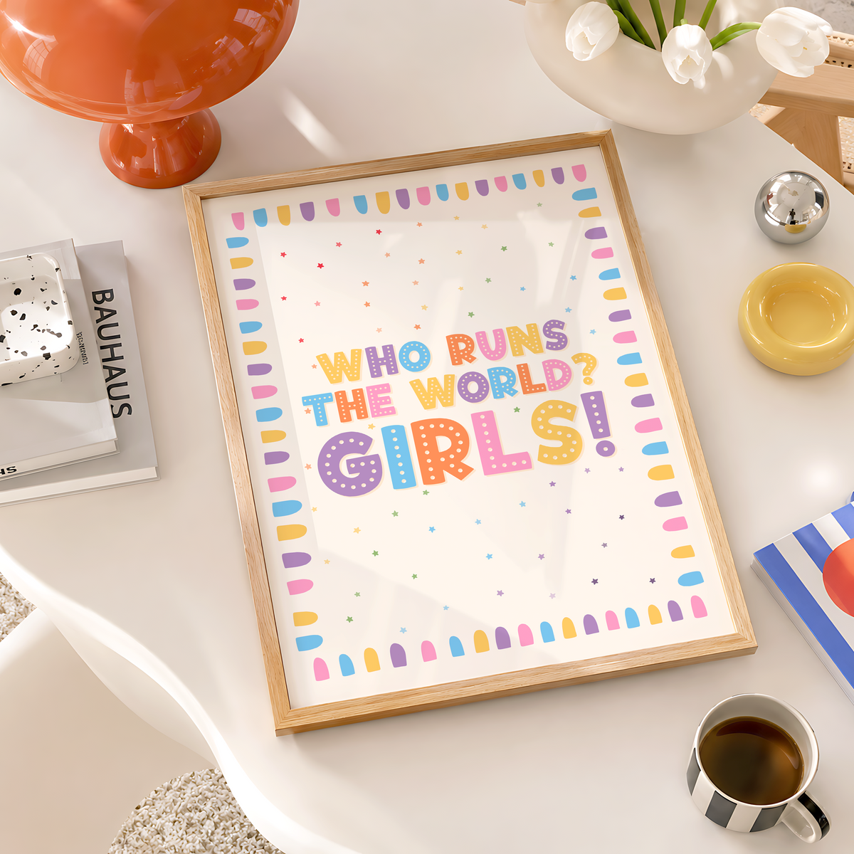 A nursery print with a colourful quote that reads 'who runs the world? GIRLS!' with a bright pastel coloured brush stroke border.