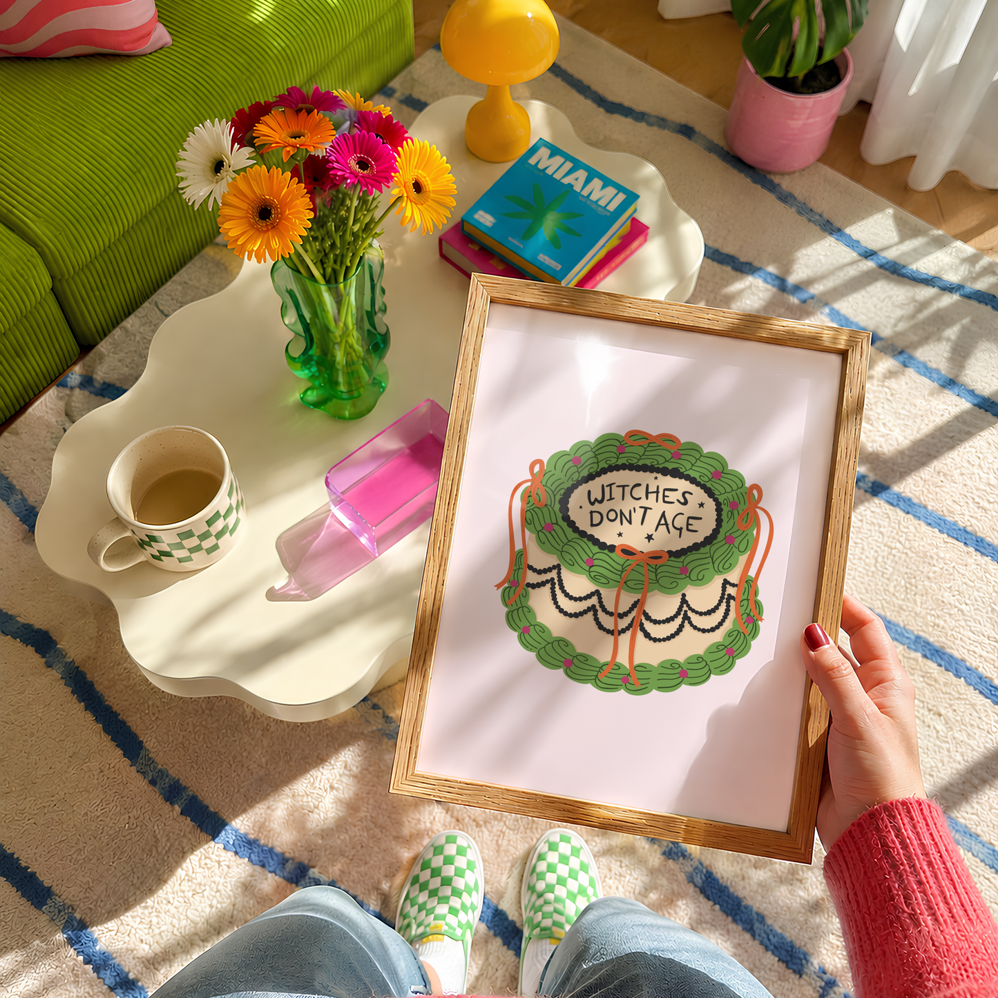 A Halloween print featuring an illustration of a cake, with green, orange and black icing. The words on top of the cake read 'witches don't age'.