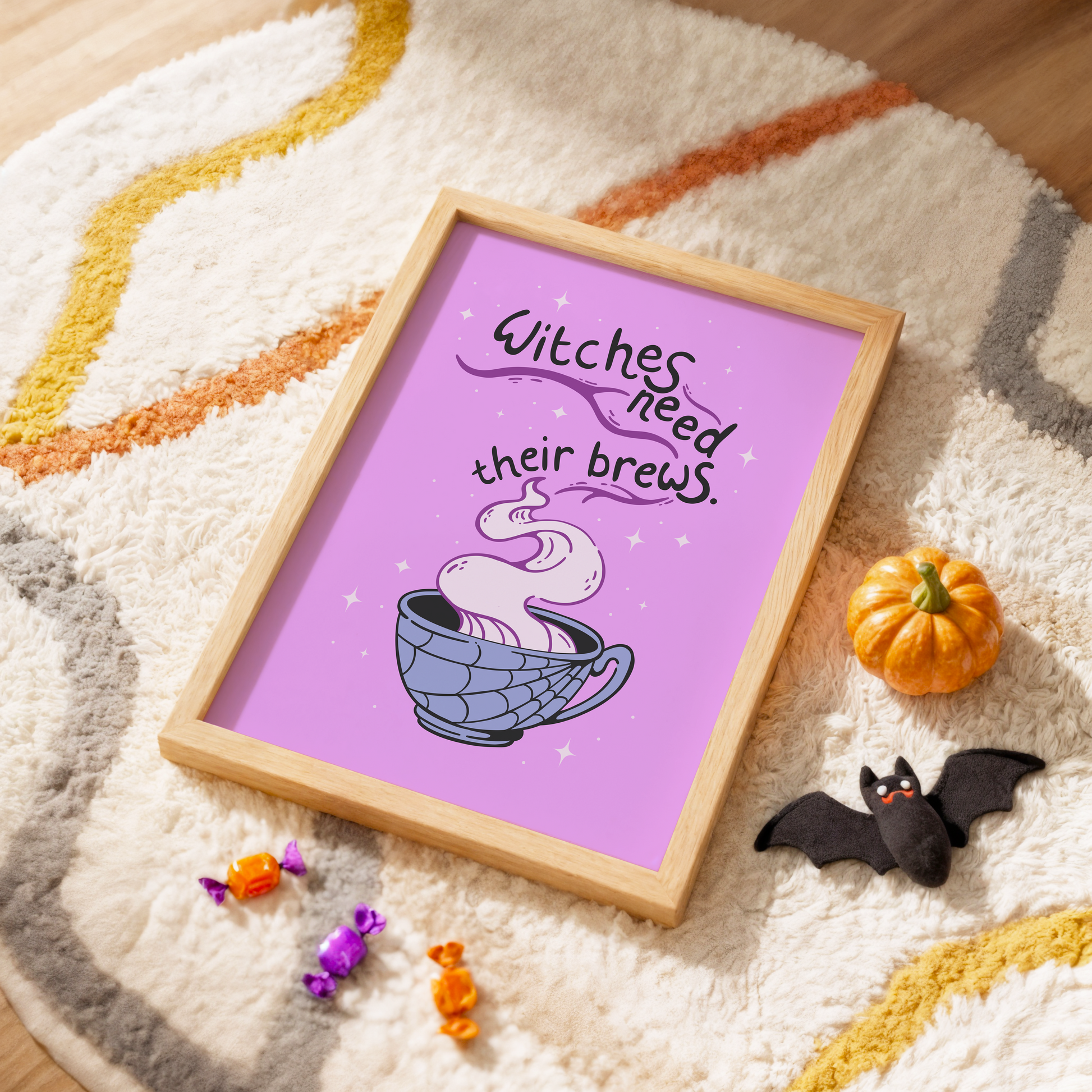 A purple Halloween illustration print, that features a spooky mug with steam coming out of it. Within the steam are the words 'witches need their brews'.