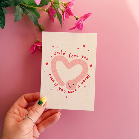 A textured postcard with an illustration of a worm in the shape of a heart, with the words 'I would love you even if you were a worm!' around the illustration.