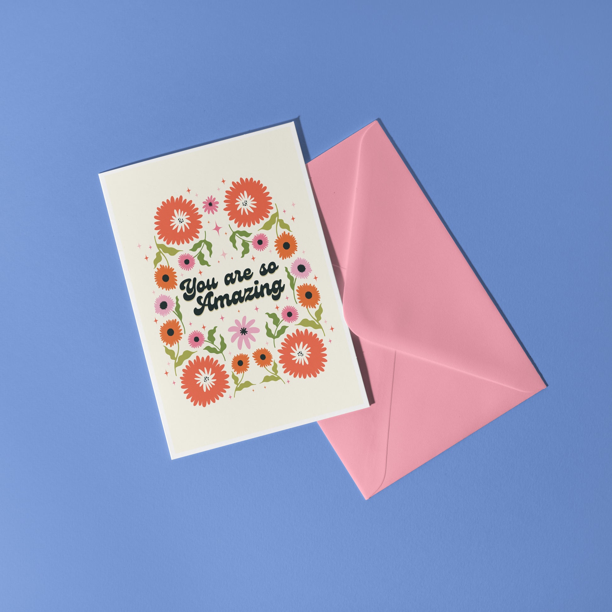 Hand holding a thank you card with 'You are so amazing' written on the front and floral detailing.