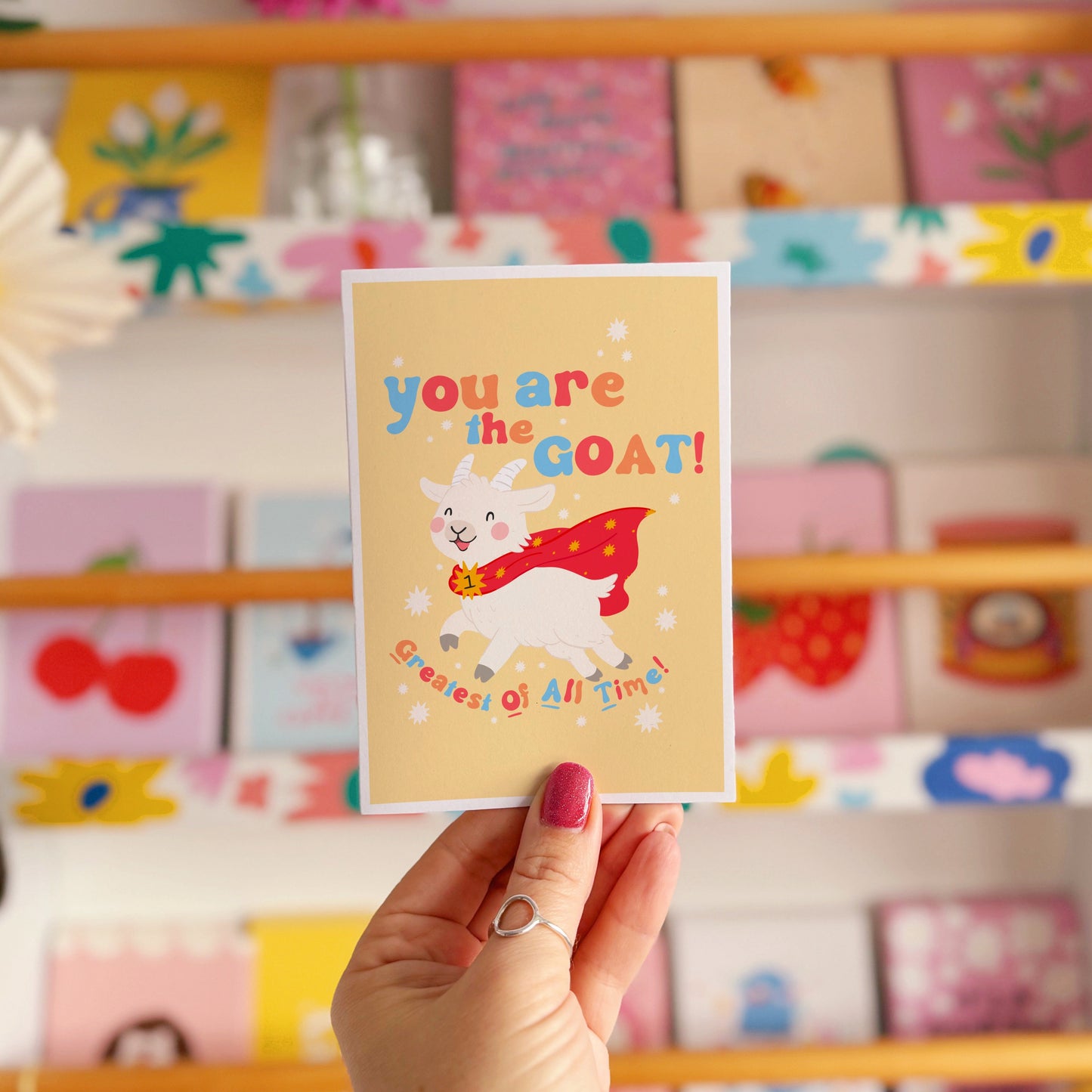 A greetings card with a goat illustration, and hand lettered text that reads 'you are the goat! (greatest of all time!)'.