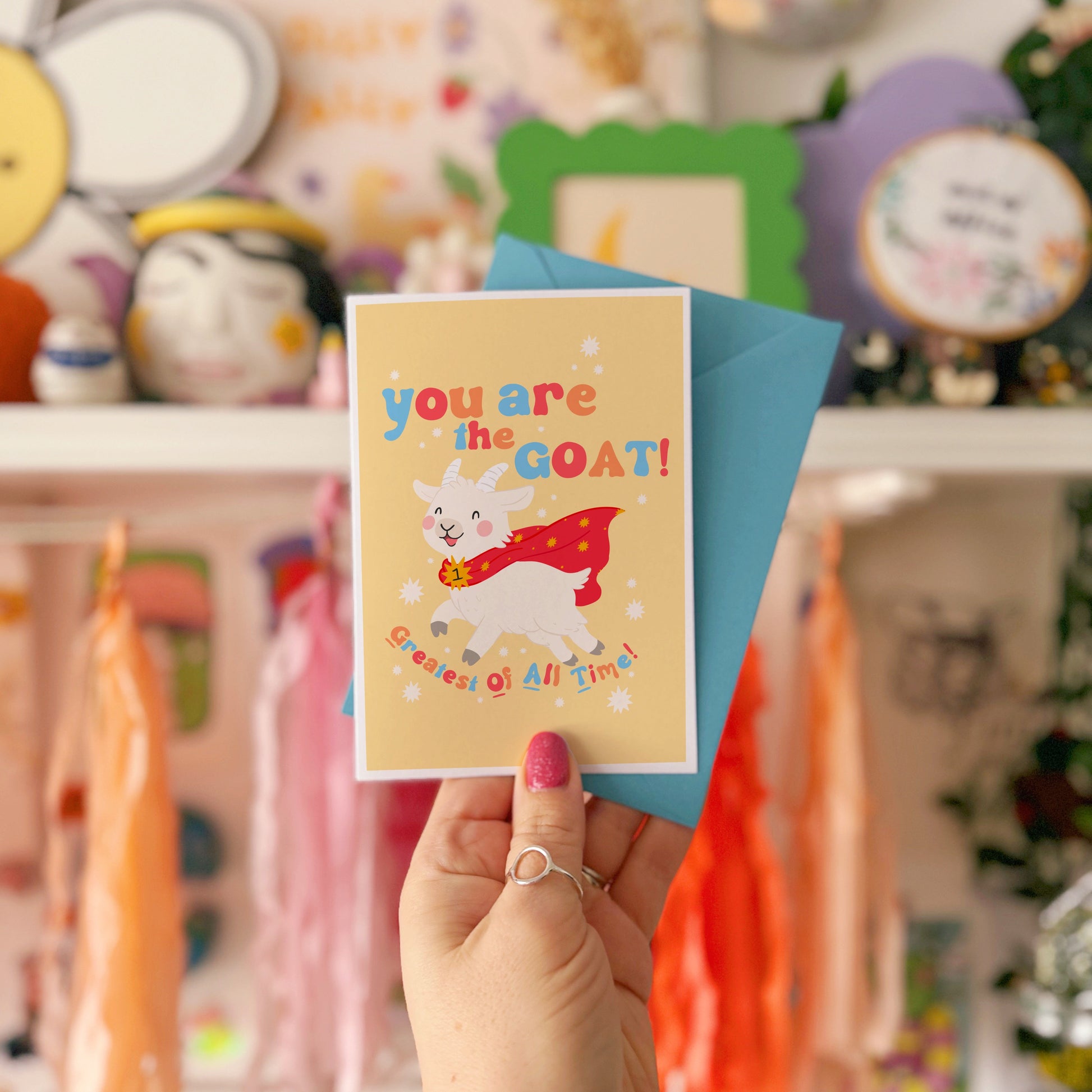 A greetings card with a goat illustration, and hand lettered text that reads 'you are the goat! (greatest of all time!)'.