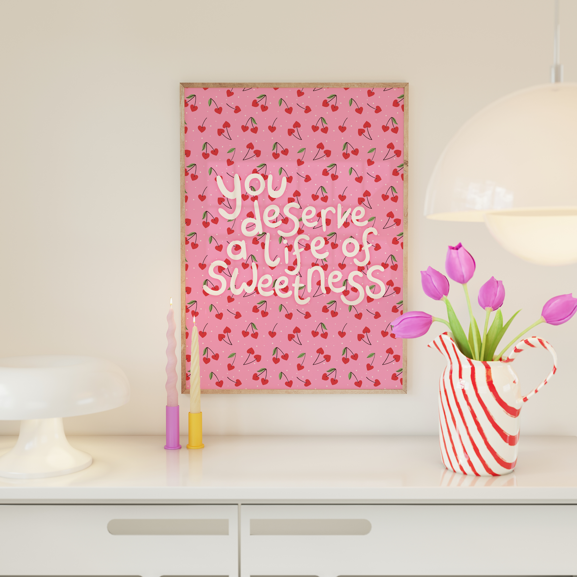 Decorative wall art with a heart shaped cherry pattern and hand lettered quote.