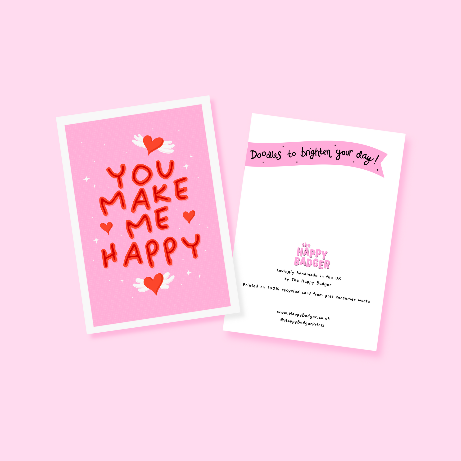 A pink greeting card with little heart illustrations around a red hand lettered quote that says 'you make me happy'.