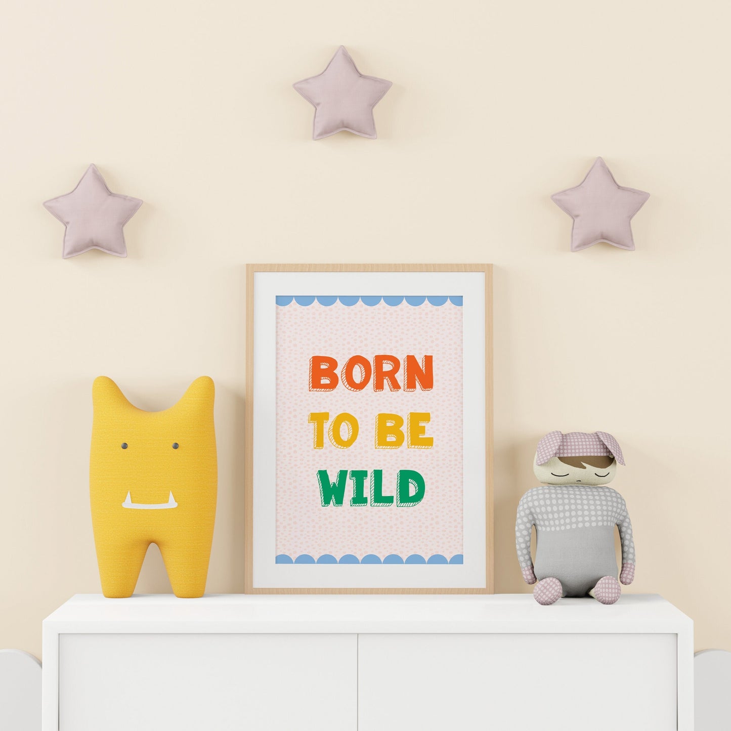 A colourful print for a kids room, saying 'born to be wild' in colourful tones, with a blue scalloped border.