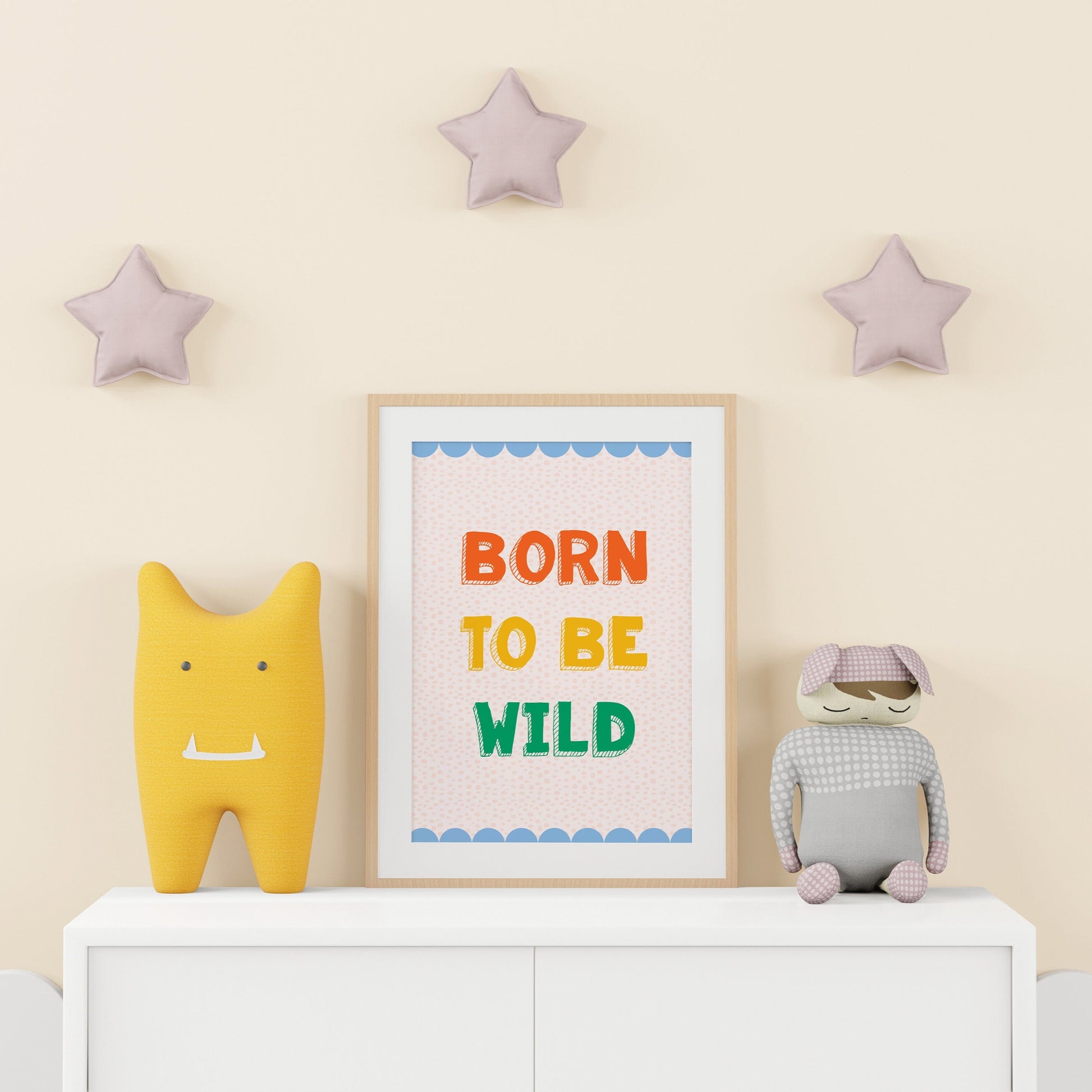 A colourful print for a kids room, saying 'born to be wild' in colourful tones, with a blue scalloped border.
