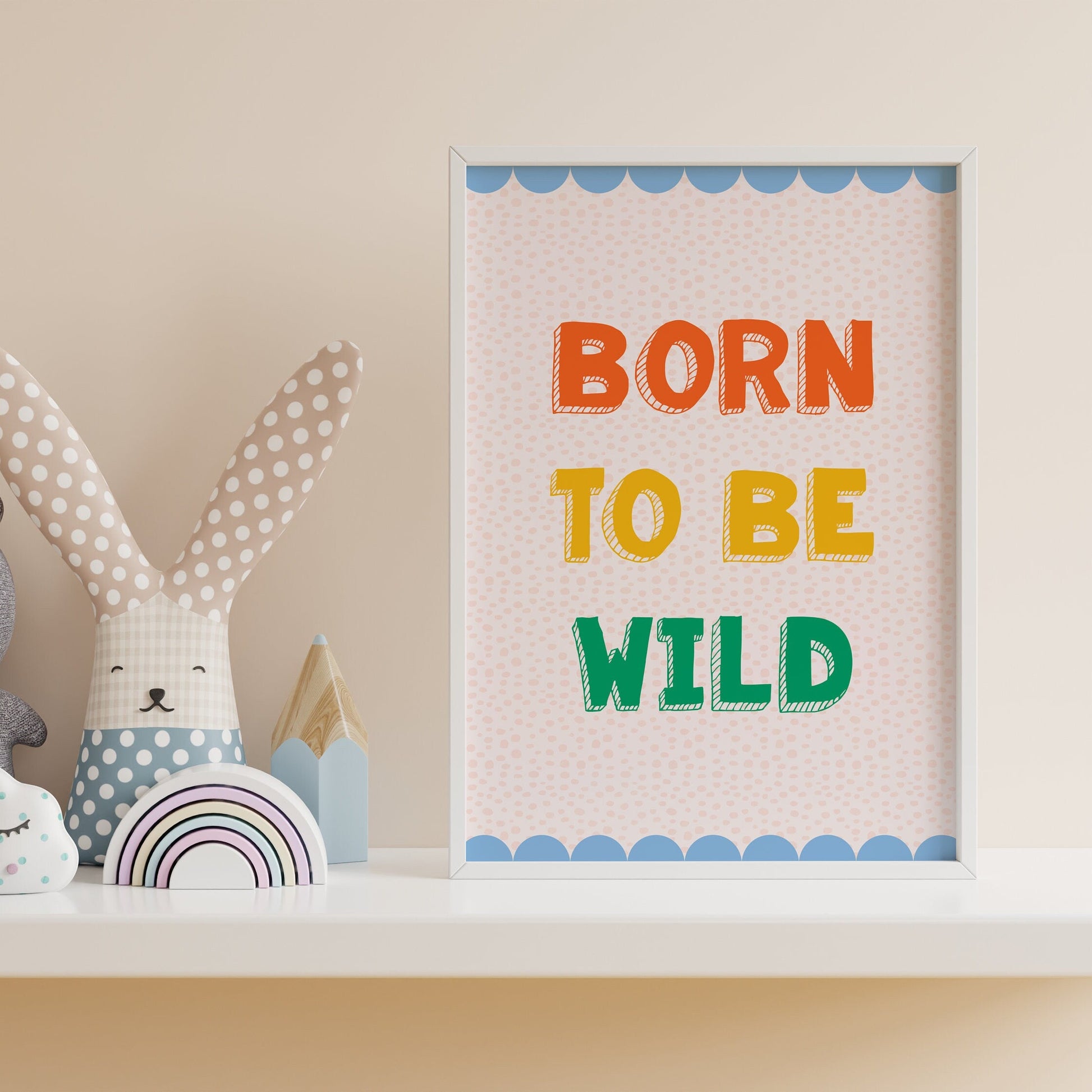 A colourful print for a kids room, saying 'born to be wild' in colourful tones, with a blue scalloped border.