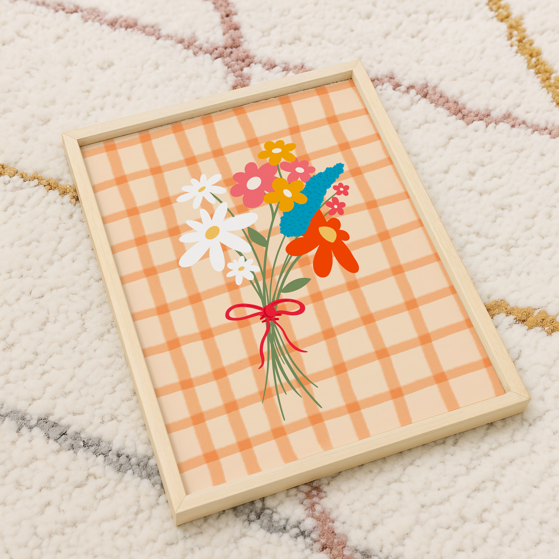 A framed art print featuring a hand-drawn bouquet of spring flowers in shades of white, pink, red, mustard, and teal on a cream and orange checkered background.