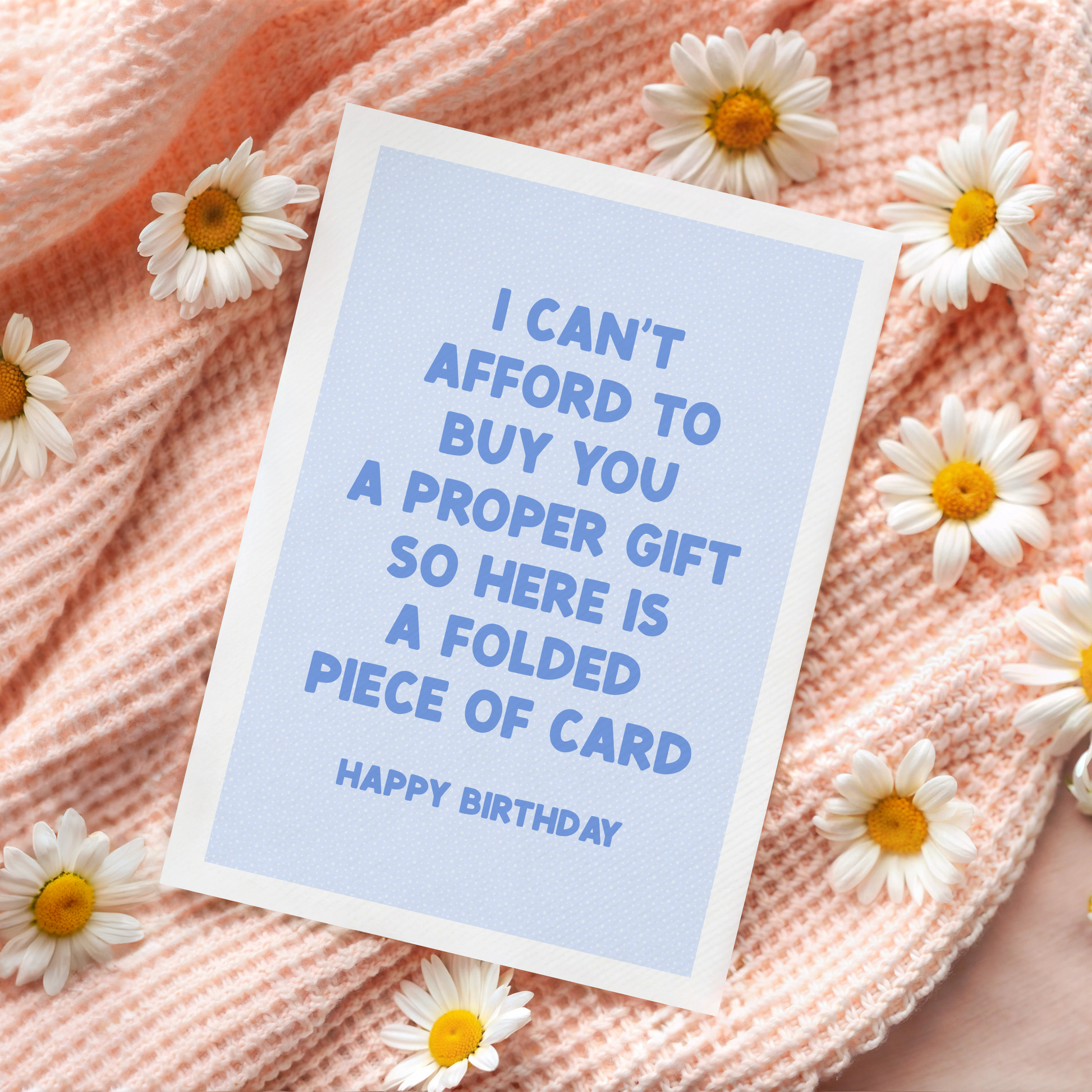 A blue card with dark blue text, saying I can't afford to buy you a proper gift so here is a folded piece of card - happy birthday.