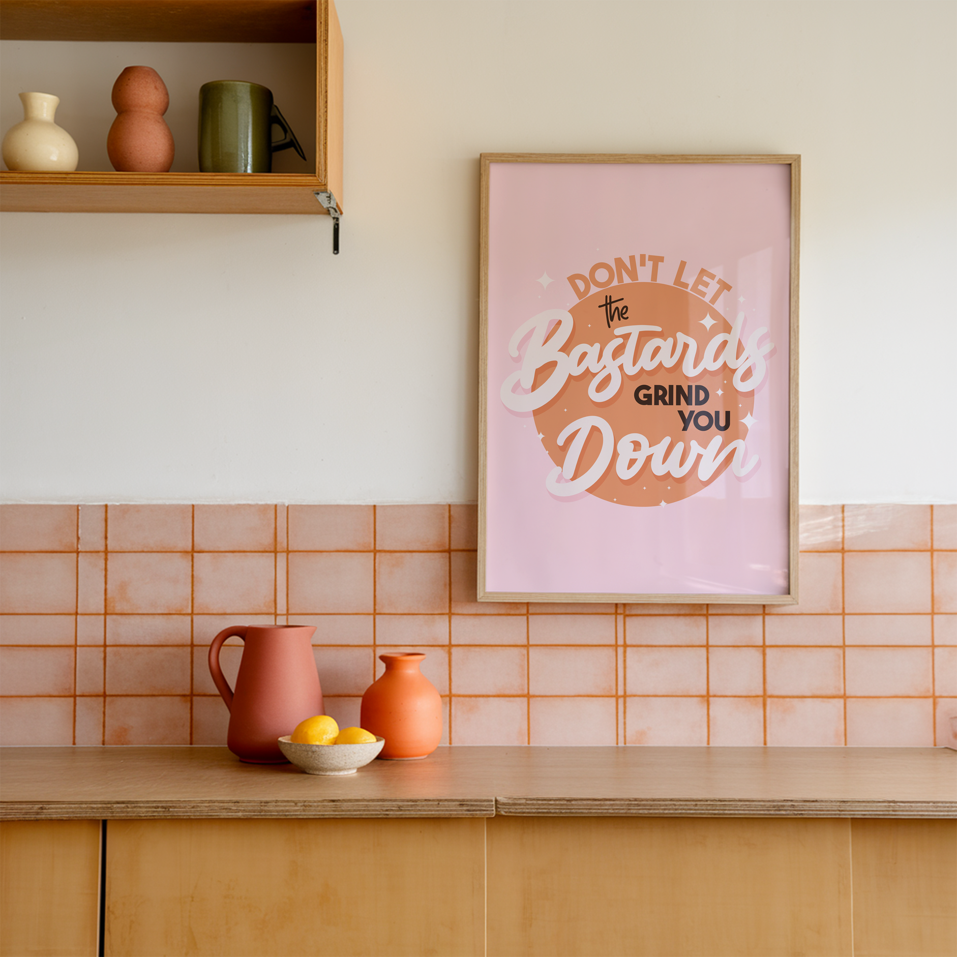 A bright pink and orange print showing a funny quote - don't let the bastards grind you down.