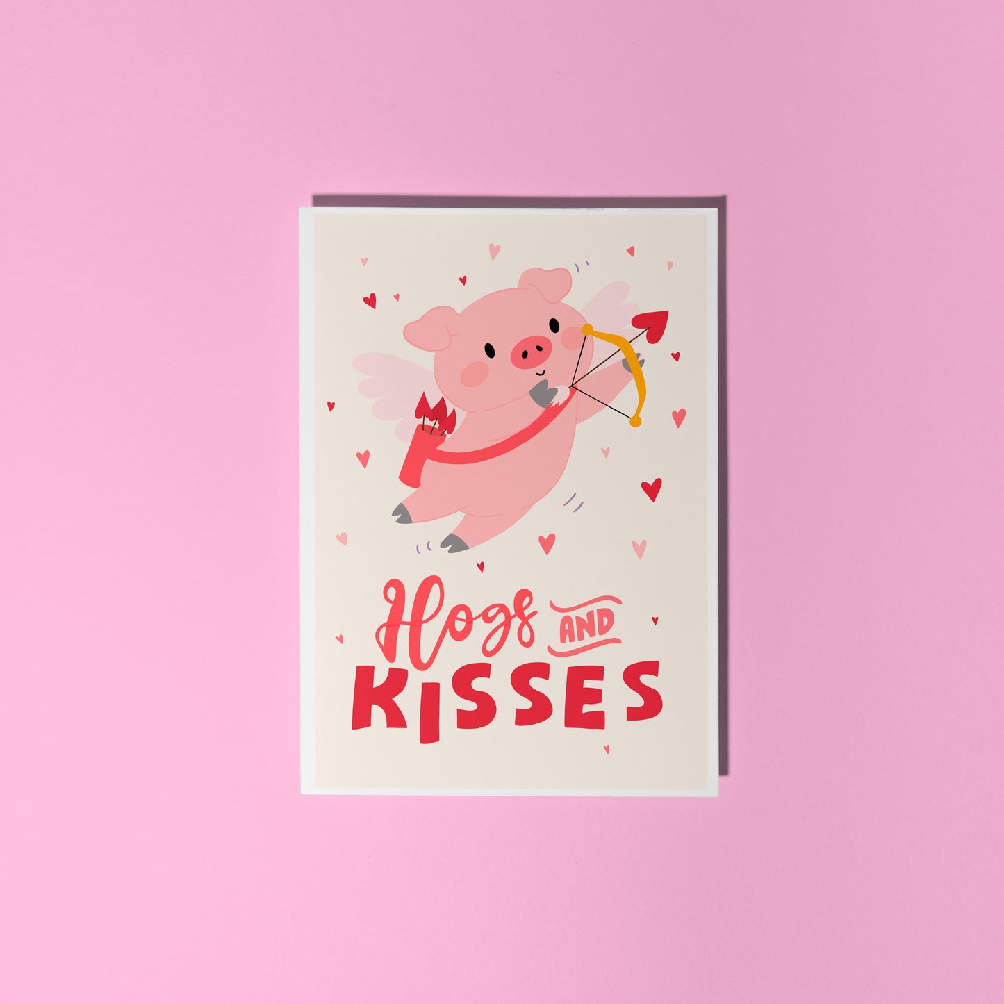 Card with a pig illustration dressed as cupid, with 'Hog and Kisses' hand written on the front of the card.