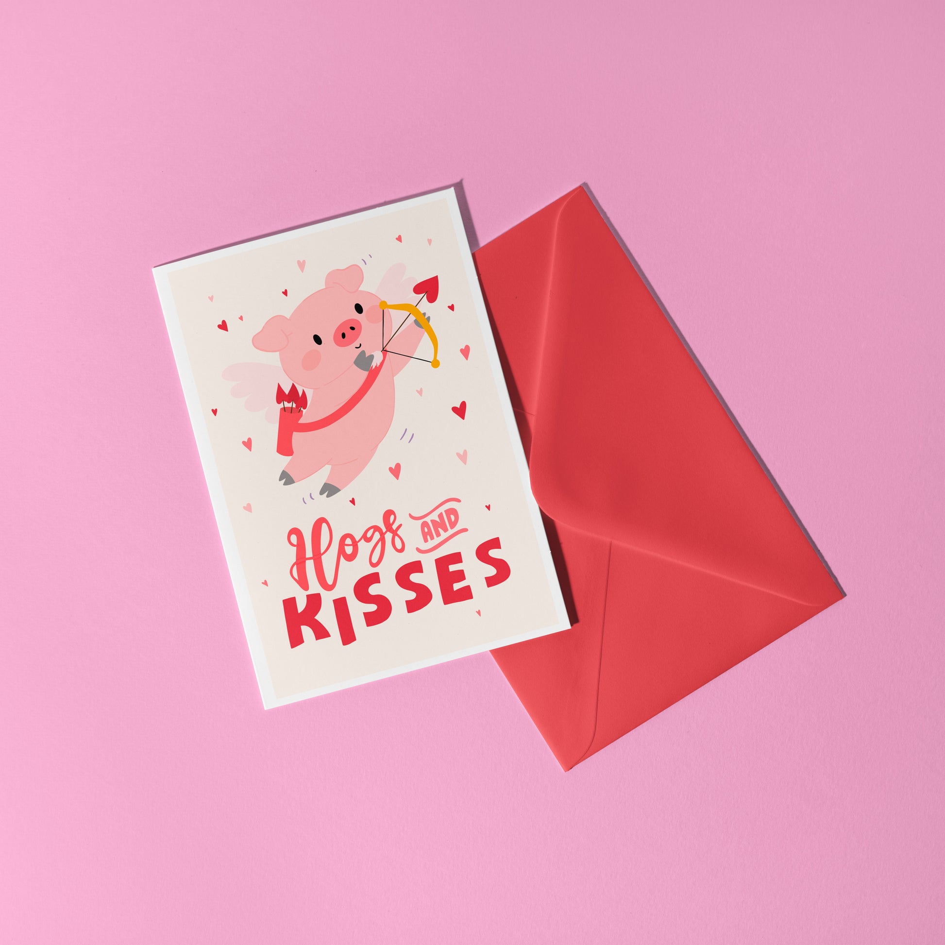 Card with a pig illustration dressed as cupid, with 'Hog and Kisses' hand written on the front of the card.